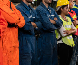 Skillful worker stand together showing teamwork in the factory . Industrial people and manufacturing labor concept .