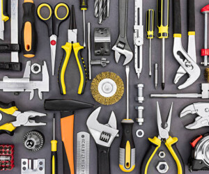 set of hand various work tools on grey background top view including different kinds of wrenches, pliers, clamps, calipers and other